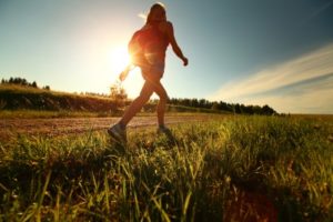 a woman walking on the sunny path